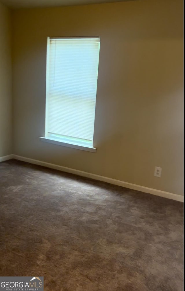 empty room featuring dark colored carpet