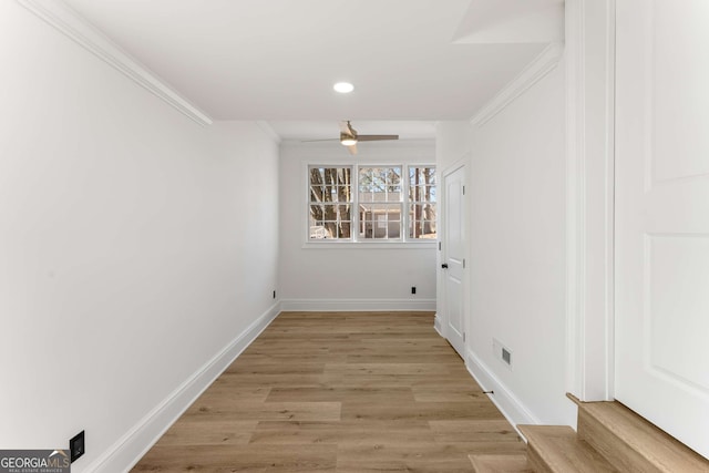 hall with light hardwood / wood-style floors and crown molding