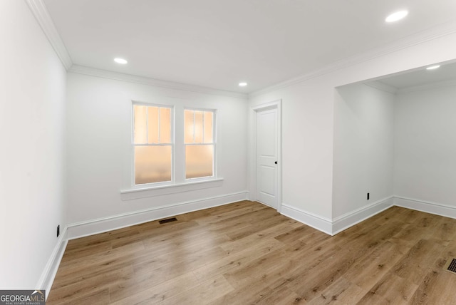 spare room featuring light hardwood / wood-style flooring and ornamental molding