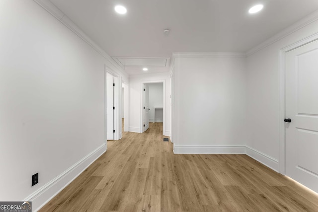 corridor with ornamental molding and light hardwood / wood-style flooring