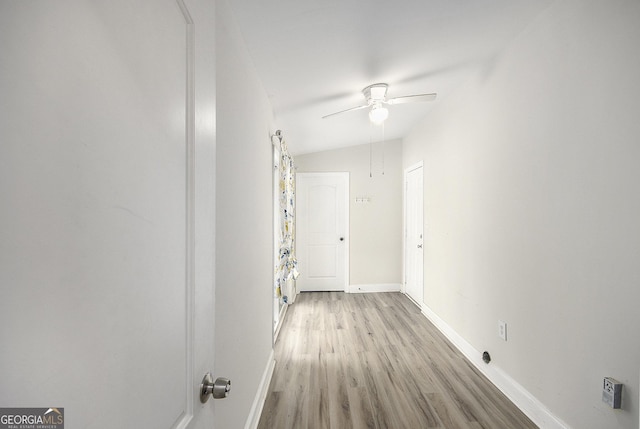 hall featuring light hardwood / wood-style floors and vaulted ceiling