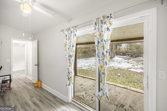 doorway with ceiling fan and wood-type flooring