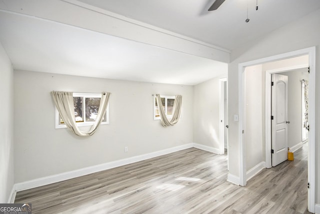 unfurnished room featuring ceiling fan, vaulted ceiling, and light wood-type flooring