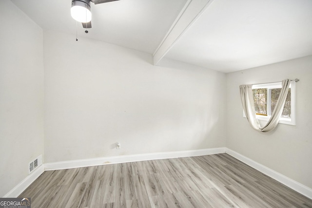 spare room featuring ceiling fan, beam ceiling, and light wood-type flooring