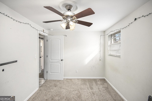 empty room featuring ceiling fan and light colored carpet