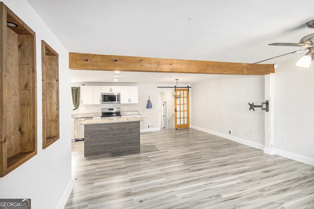 living room with beamed ceiling, ceiling fan with notable chandelier, and light hardwood / wood-style flooring