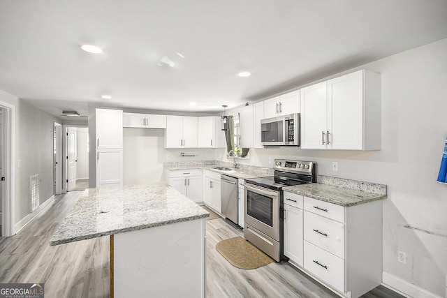 kitchen with light stone countertops, white cabinets, and stainless steel appliances