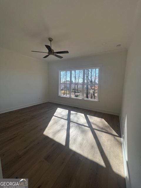 spare room with dark hardwood / wood-style floors and ceiling fan