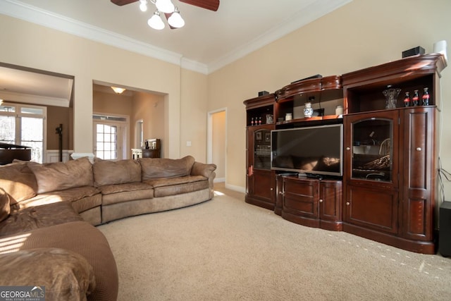 living room with crown molding, ceiling fan, and carpet