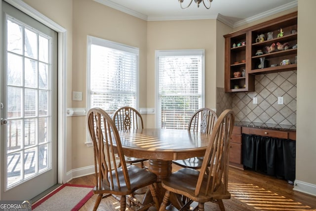 dining room featuring ornamental molding, dark wood-type flooring, and a chandelier