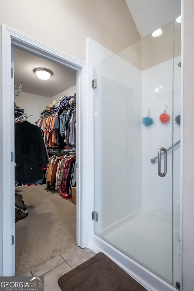 bathroom featuring tile patterned floors and a shower with shower door