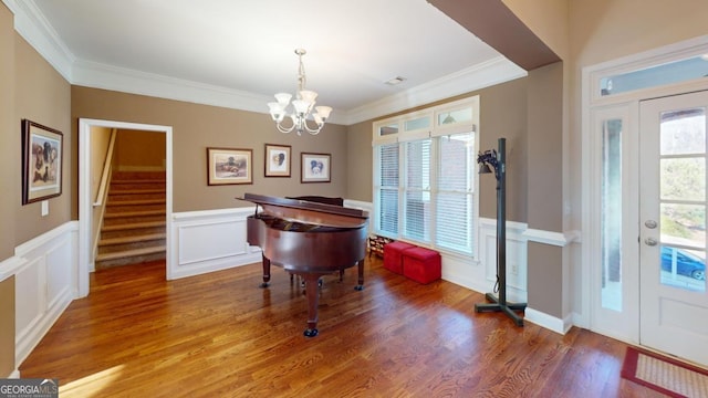 misc room featuring a notable chandelier, wood-type flooring, and ornamental molding