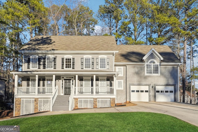 view of front of house featuring a porch, a garage, and a front lawn