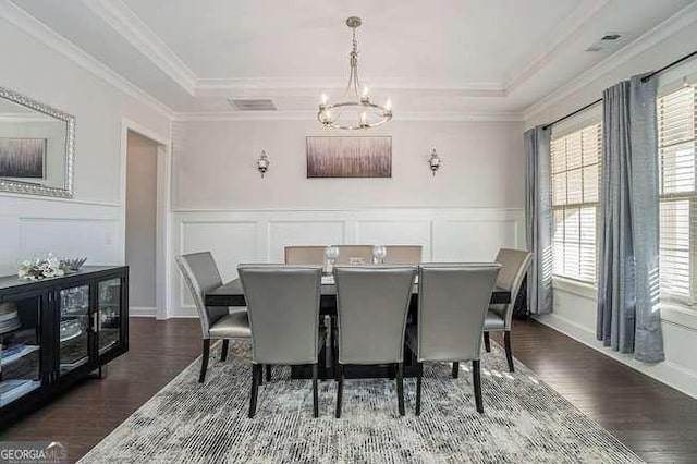 dining room with plenty of natural light, dark hardwood / wood-style flooring, ornamental molding, and a chandelier