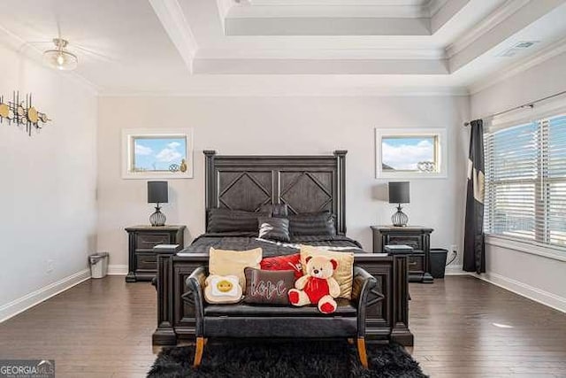 bedroom featuring dark hardwood / wood-style flooring, a raised ceiling, and ornamental molding