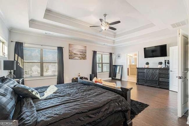 bedroom featuring ceiling fan, dark hardwood / wood-style floors, a raised ceiling, and crown molding