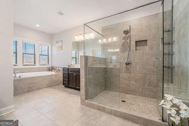 bathroom featuring tile patterned floors, plus walk in shower, and vanity