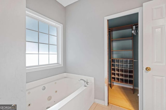 bathroom with a bath, tile patterned floors, and plenty of natural light