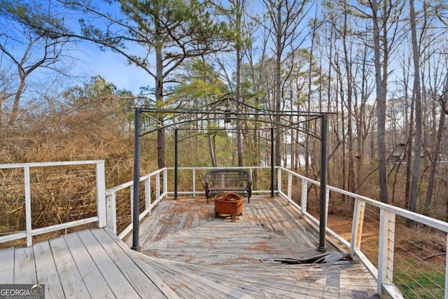 wooden deck featuring a gazebo and a fire pit