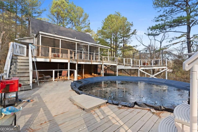 back of house featuring a sunroom and a deck