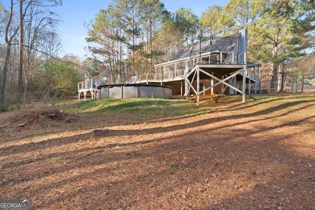 back of house featuring a swimming pool side deck