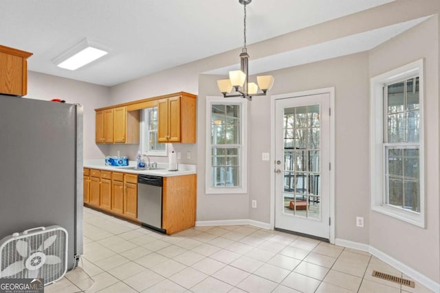 kitchen featuring stainless steel appliances, sink, light tile patterned floors, a chandelier, and hanging light fixtures