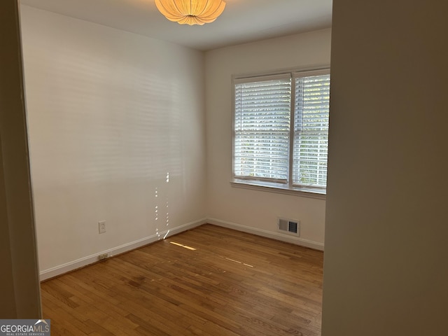 unfurnished room with wood-type flooring