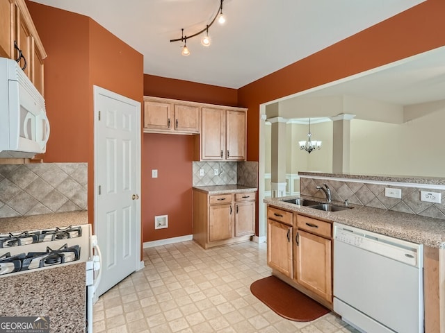 kitchen featuring decorative backsplash, white appliances, sink, pendant lighting, and a notable chandelier