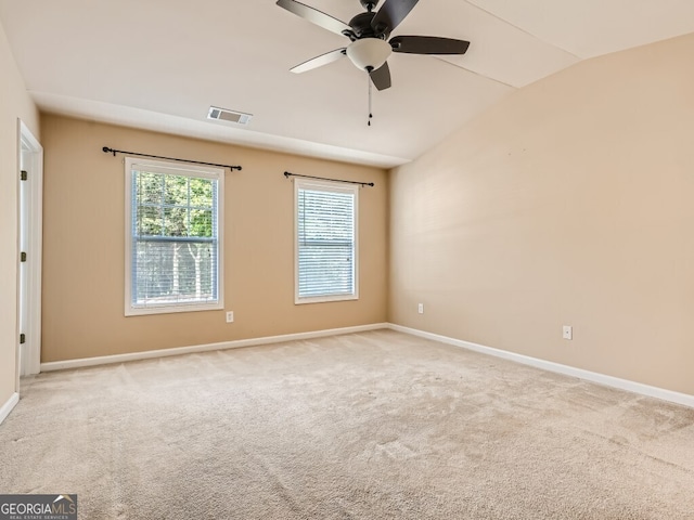 carpeted spare room featuring ceiling fan and vaulted ceiling