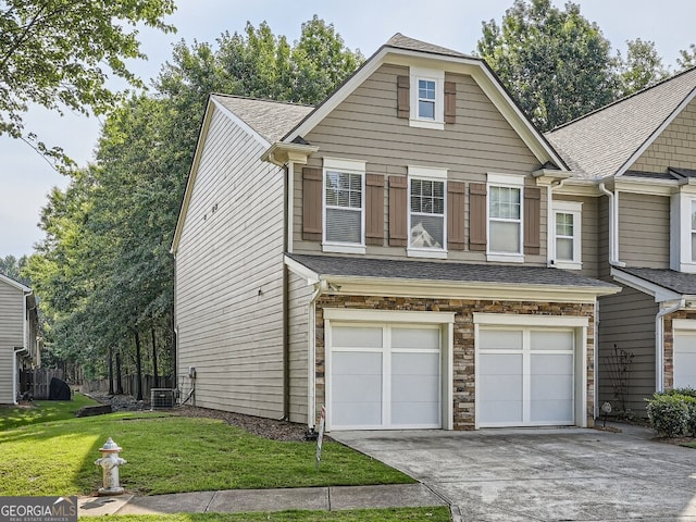 view of front of property with central AC unit, a garage, and a front lawn