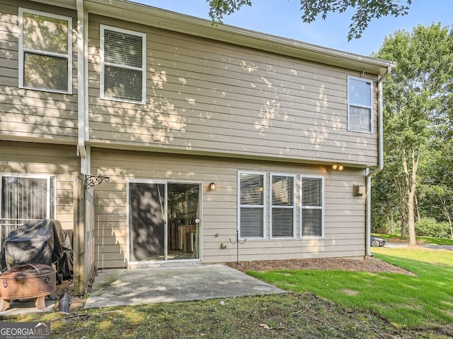 rear view of house featuring a patio area and a yard