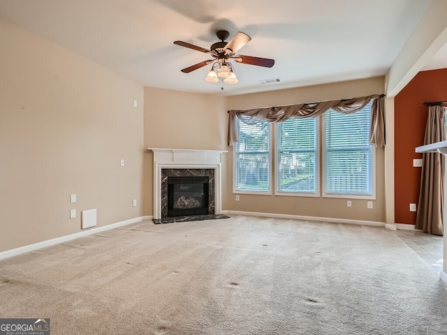 unfurnished living room featuring ceiling fan, light colored carpet, and a fireplace