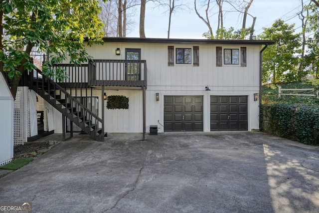 view of front of house with a garage, central AC, and a balcony