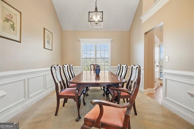 carpeted dining room with lofted ceiling and a chandelier