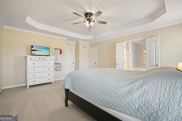 carpeted bedroom with a tray ceiling, ceiling fan, and ornamental molding