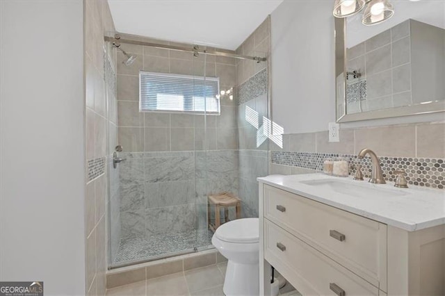 bathroom with tasteful backsplash, tile patterned floors, an enclosed shower, toilet, and vanity