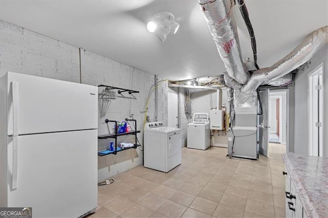 basement featuring washing machine and dryer, heating unit, and white refrigerator