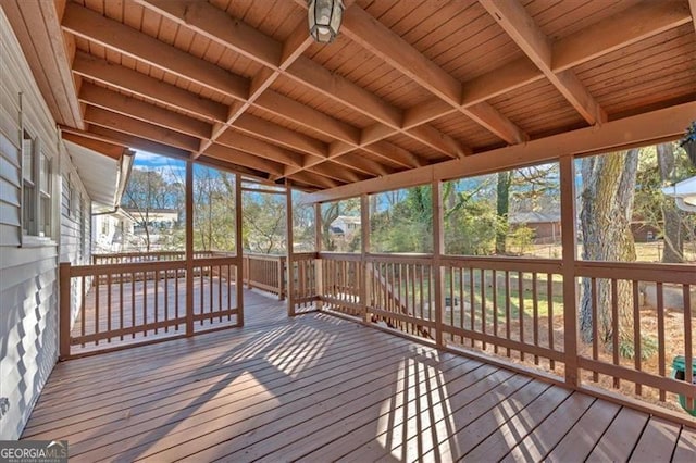 unfurnished sunroom with beamed ceiling