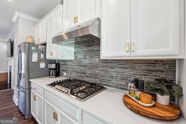 kitchen with white cabinets, appliances with stainless steel finishes, exhaust hood, dark hardwood / wood-style floors, and crown molding