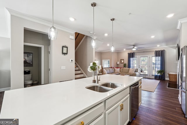 kitchen with crown molding, pendant lighting, dark hardwood / wood-style flooring, sink, and appliances with stainless steel finishes