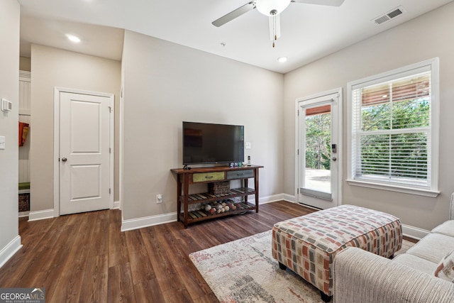 living room with ceiling fan and dark hardwood / wood-style flooring