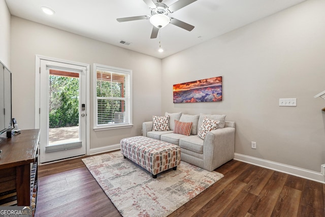 living room with ceiling fan and dark hardwood / wood-style flooring