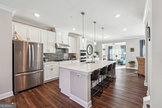 kitchen with pendant lighting, white cabinetry, a kitchen island with sink, and appliances with stainless steel finishes