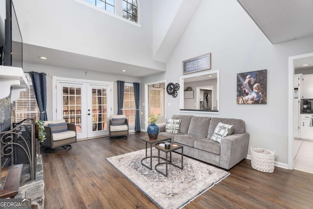 living room with a wealth of natural light, french doors, dark hardwood / wood-style floors, and a high ceiling