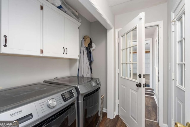 clothes washing area featuring dark hardwood / wood-style flooring, washer and clothes dryer, and cabinets