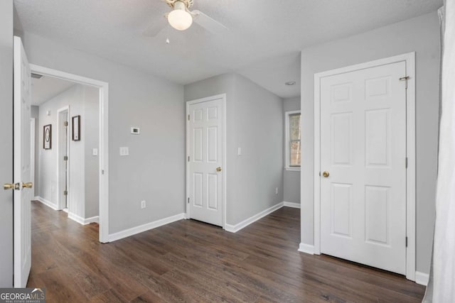 interior space with a textured ceiling, ceiling fan, and dark hardwood / wood-style floors