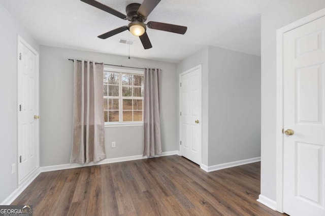 unfurnished room featuring dark hardwood / wood-style flooring and ceiling fan