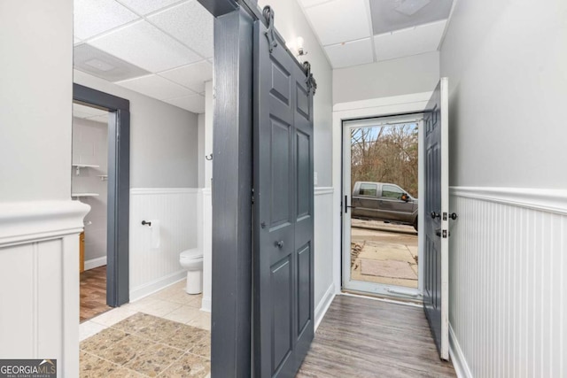 entryway with a barn door and a paneled ceiling