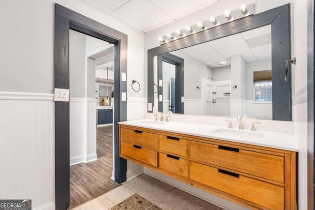 bathroom featuring a shower, vanity, tile patterned floors, and a paneled ceiling