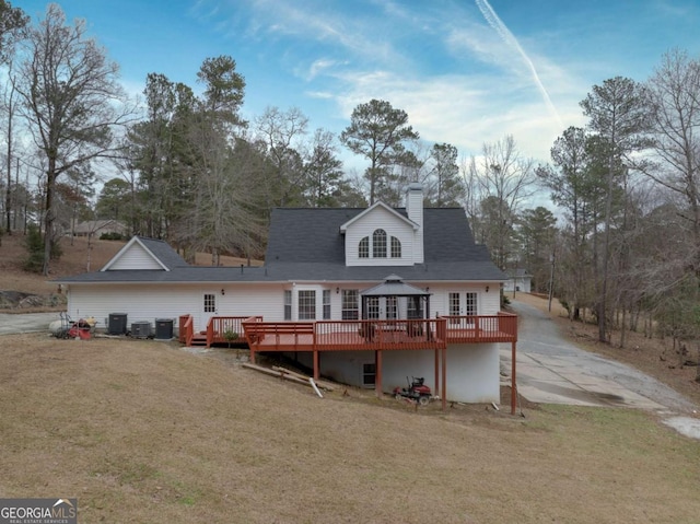 back of property with a yard, cooling unit, and a deck